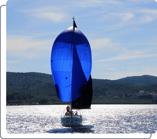 A sail boat sailing on the water near shore.