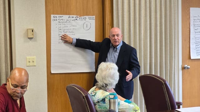 A man standing in front of a board with a woman.